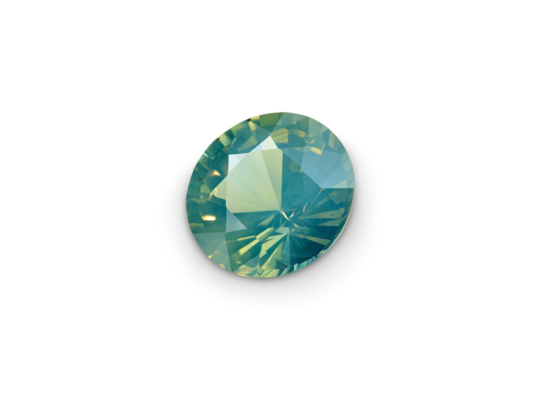 1.85ct Opalescent Teal Sapphire Round Brilliant on white background to show scale.
