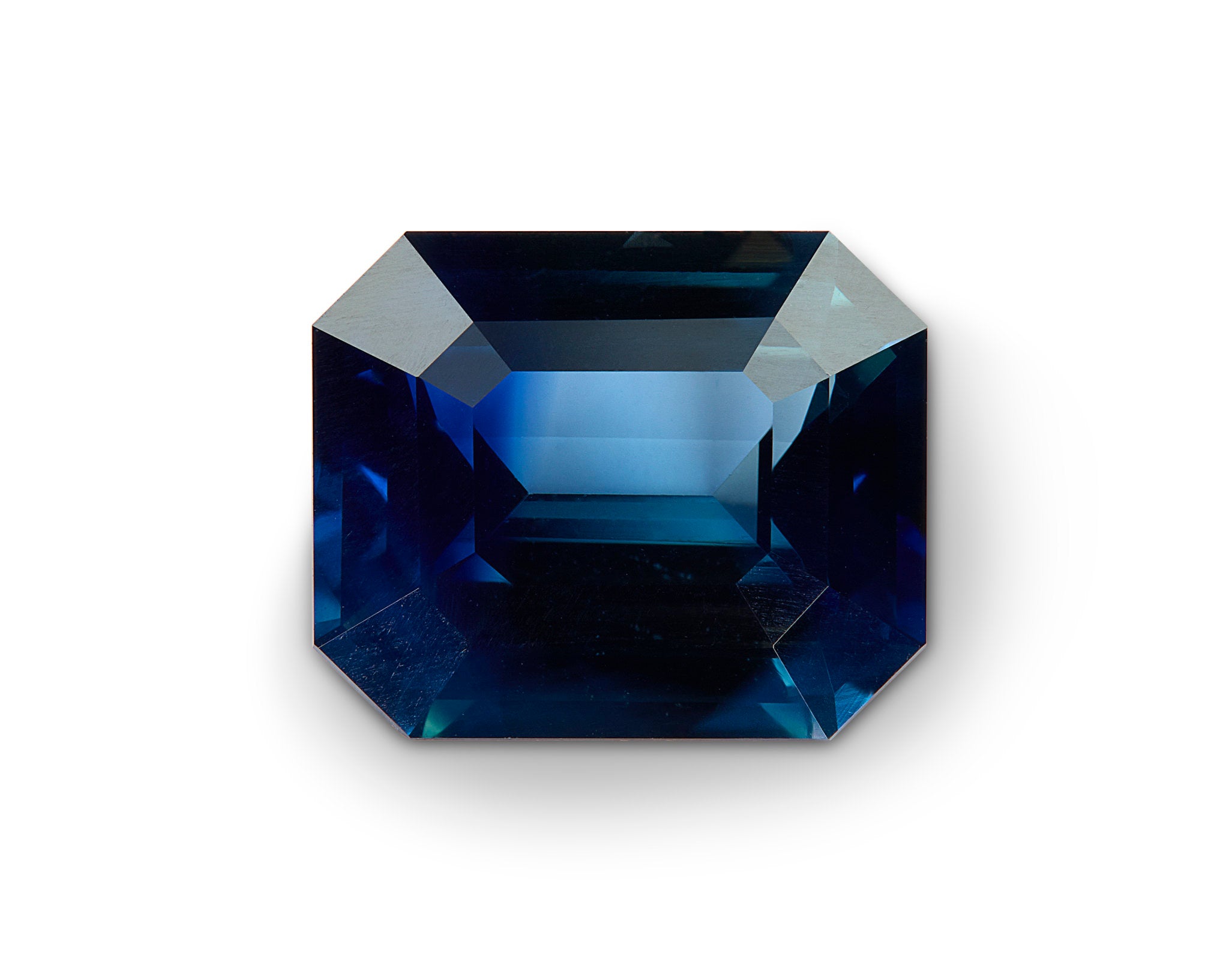 Faceted blue gemstone on a white background